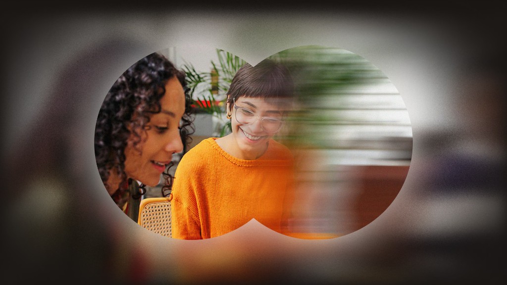 Two team members smiling and working together, seen through a stylized binocular overlay, representing Talentium's collaborative culture.